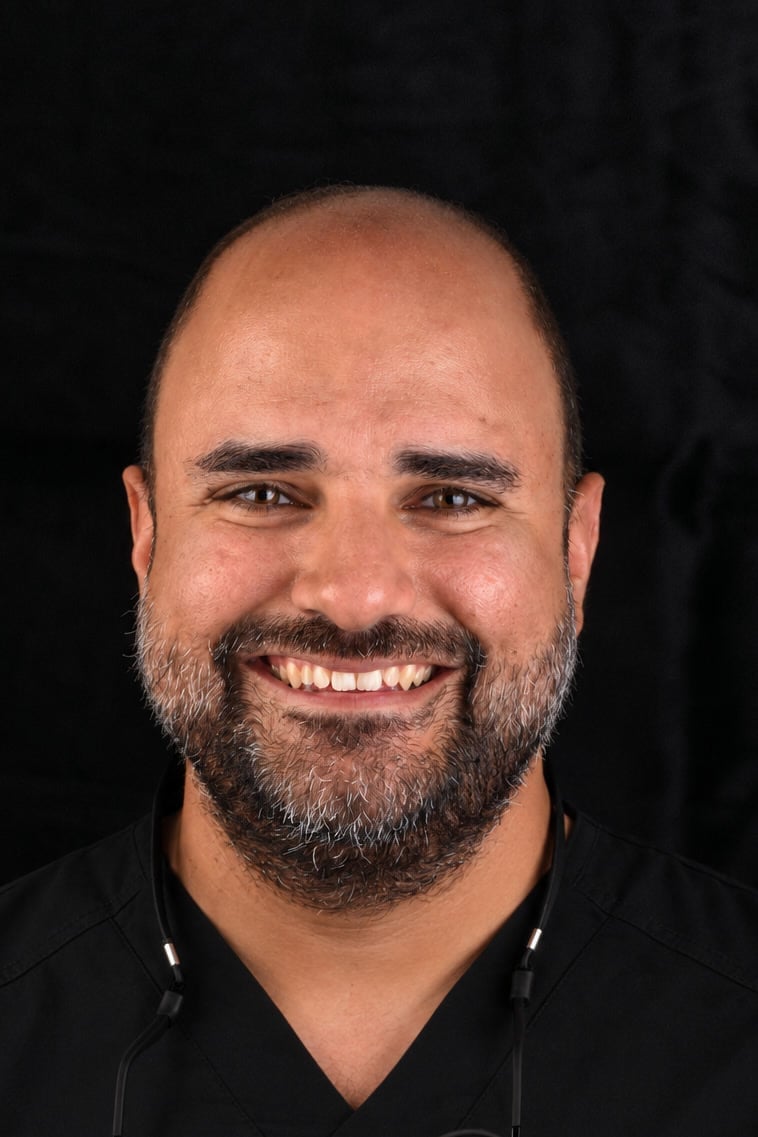 Dr. José Carlos Saint-Hilaire, smiling, wearing dental loupes
